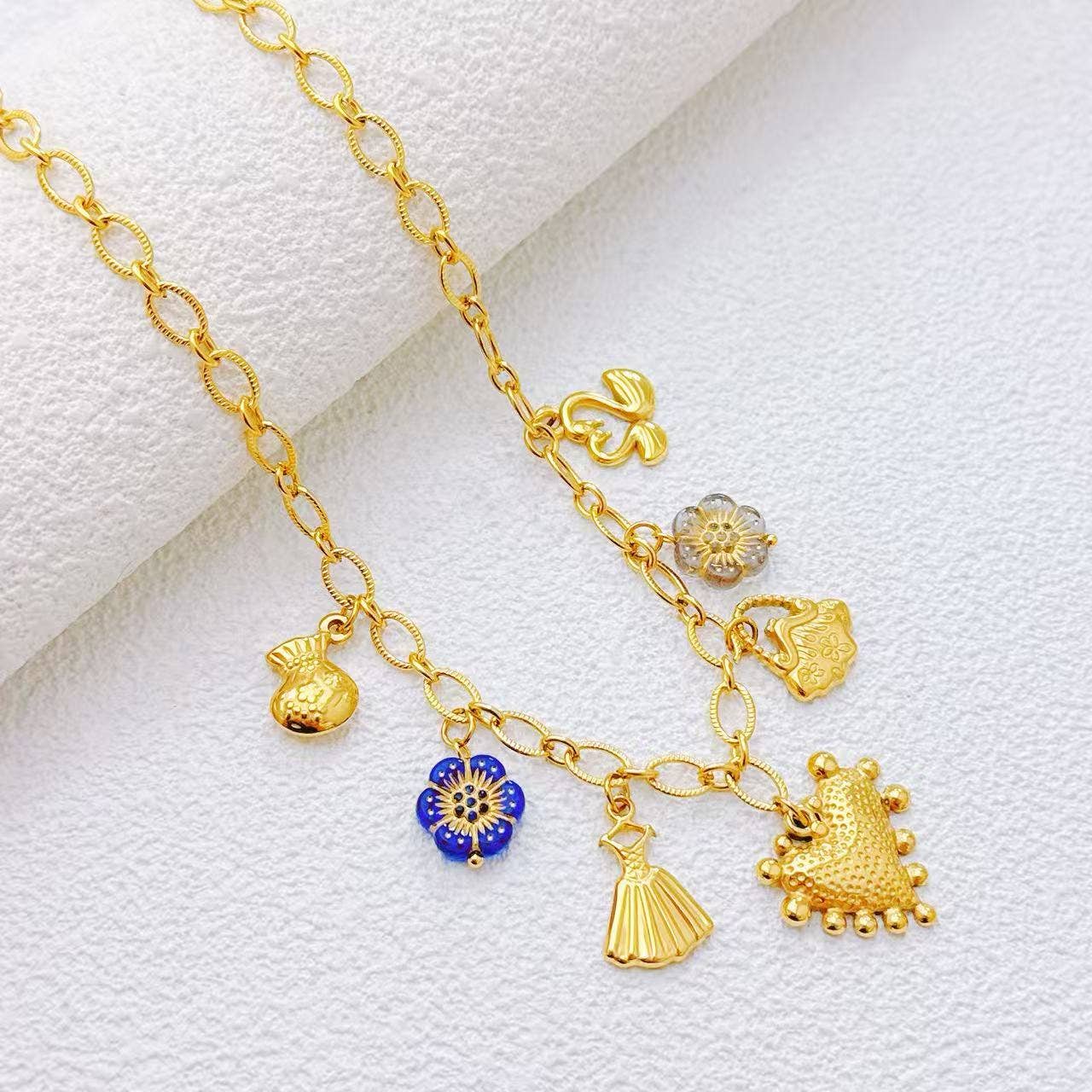 Collana dorata con charms assortiti in acciaio inossidabile, motivo simbolico